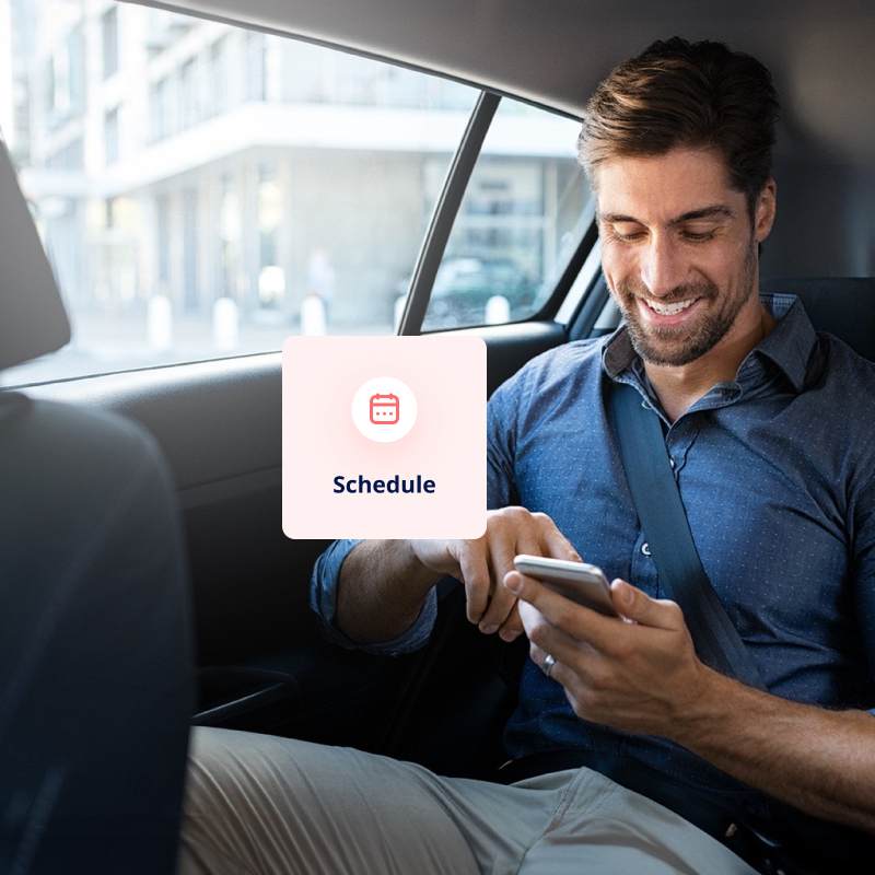 A man looking at his phone while inside of a car.